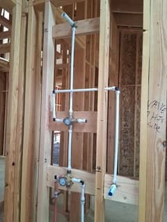Shower piping and valve connections before wall finishes