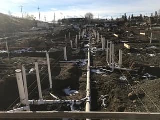 Rows of plumbing risers and piping before the building slab is poured