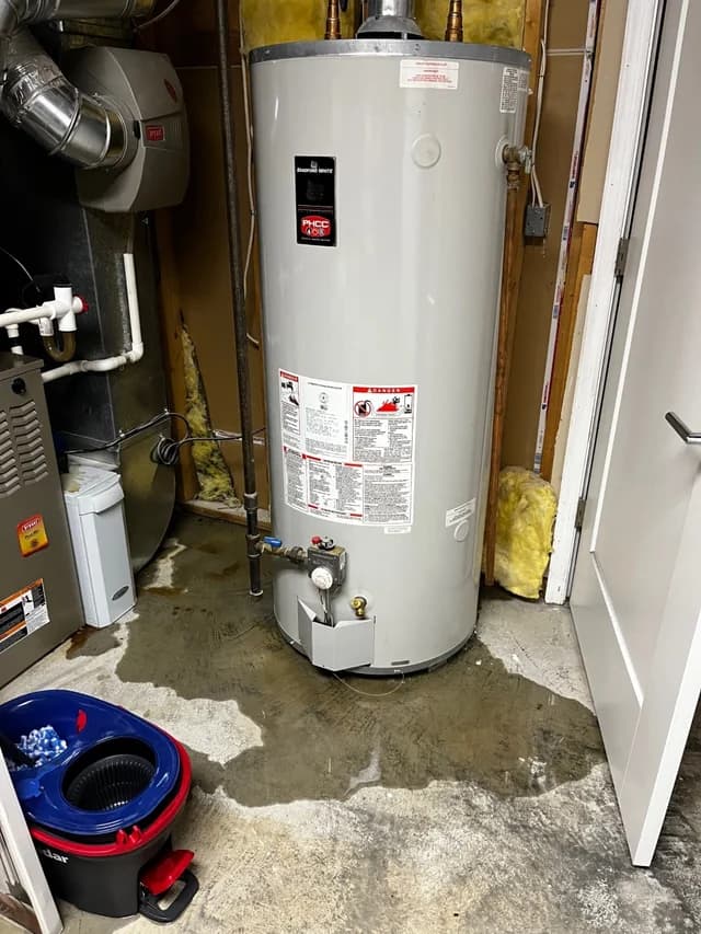 Water pooling around the base of a leaking water heater